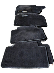 A set of black WK2 Grand Cherokee Floor mats Front and Rear  mats show the Jeep logo, indicating the brand is original Genuine Jeep.