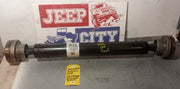 A pre-owned Jeep WK2 Grand Cherokee drive shaft displayed on a table with a Jeep City onlinebranded backdrop.