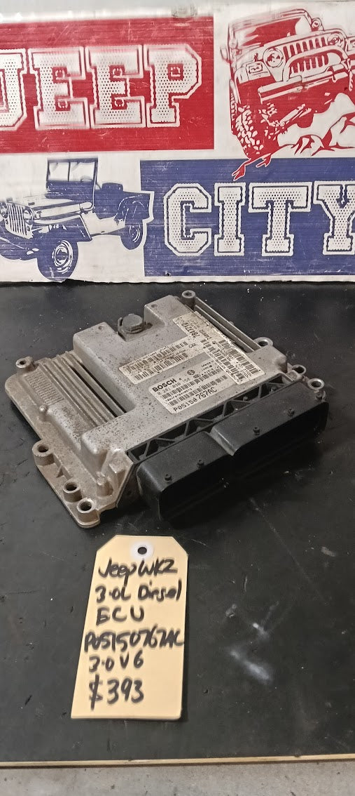 Car electronic control unit 05150767AC on a black surface with a 'Jeep City' sign in the background.