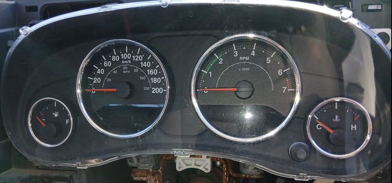 Car dashboard with speedometer and other gauges on a dark background
