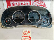 Car dashboard with gauges on a white surface, with a red and white sign in the background.