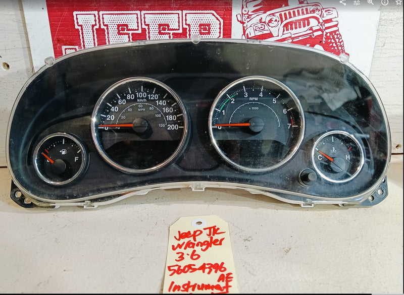 Car dashboard with gauges on a white surface, with a red and white sign in the background.