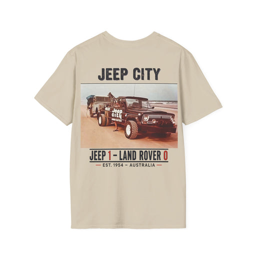 A beige short-sleeve t-shirt with a vintage-style graphic print on the front featuring a black Jeep and a Land Rover in a desert setting, with text reading 'JEEP CITY' and 'JEEP 1 - LAND ROVER 0'.