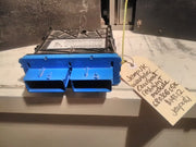 A blue airbag restraint module for a Jeep JK Wrangler, placed on a concrete surface with a handwritten label providing vehicle information.